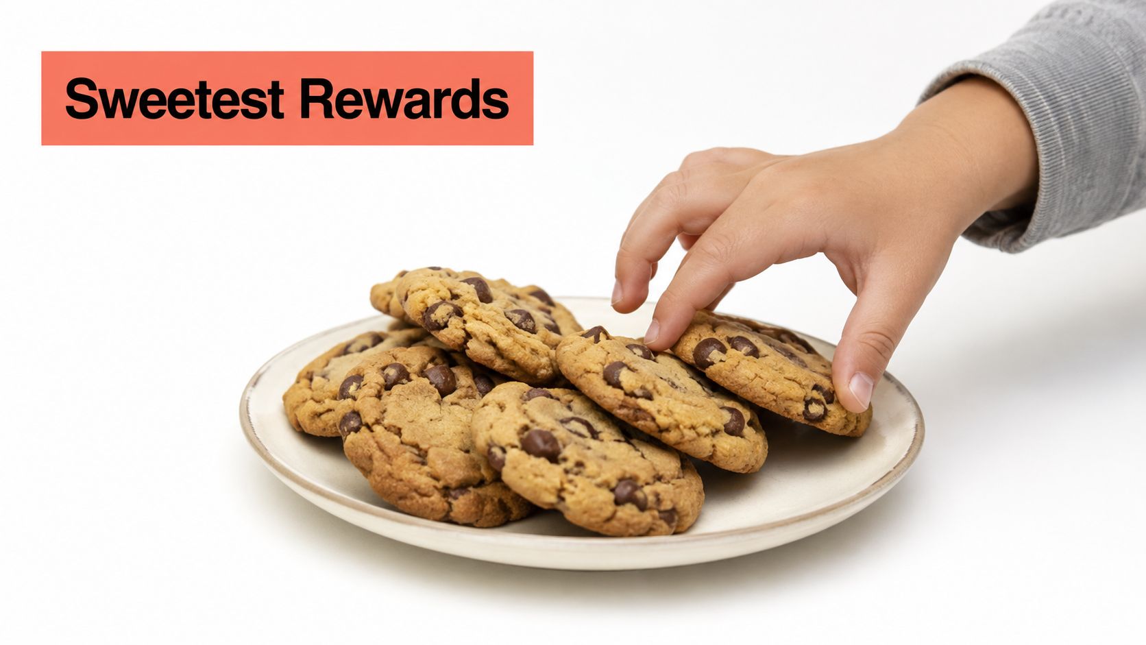 A child's hand reaching for a delicious chocolate chip cookie on a white plate, symbolizing a reward.