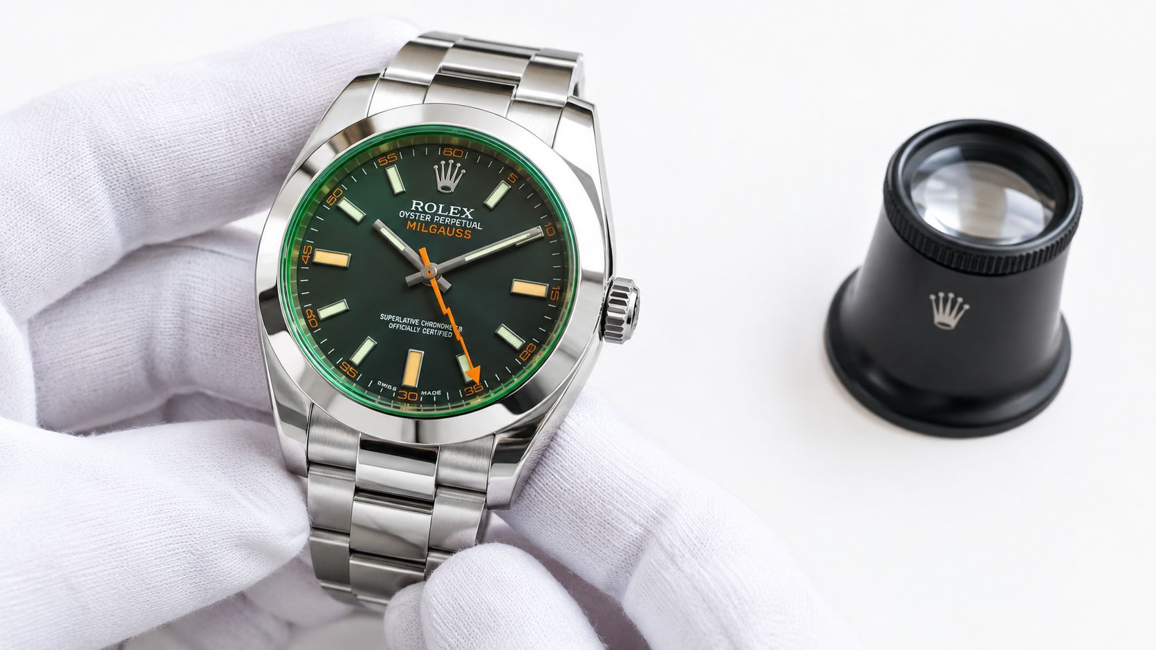 A gloved hand holds a Rolex Milgauss luxury watch next to a professional watchmaker loupe on white.