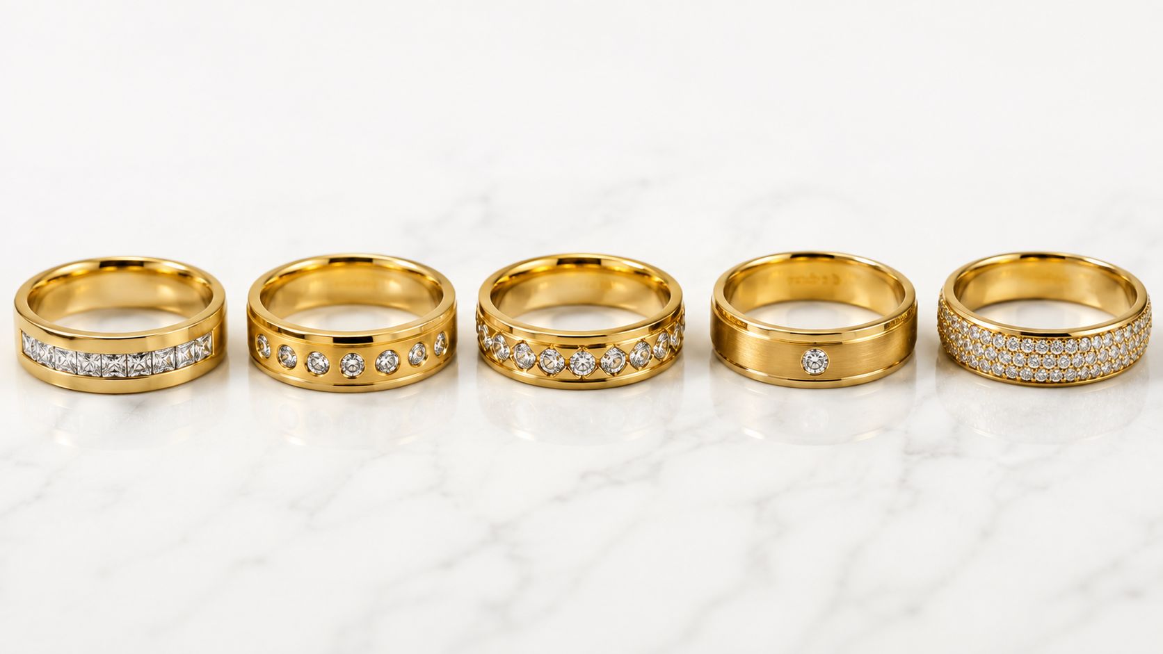 A row of five luxury men's diamond wedding bands crafted in polished yellow gold on marble surface.