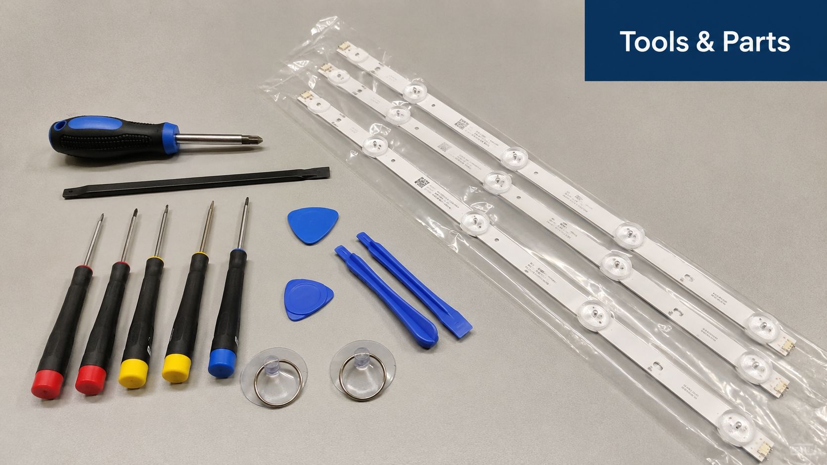 A collection of repair tools and LED backlight strips for a TV repair project on a table.