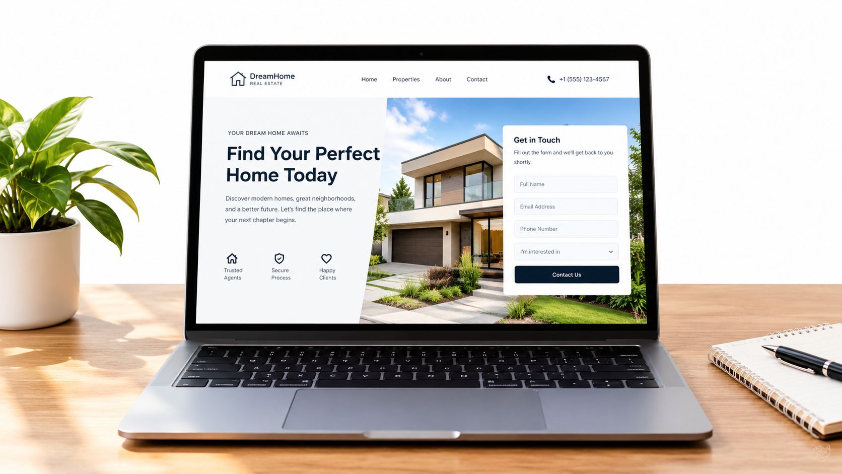 A modern laptop on a wooden desk displaying a real estate agency website with a contact form.