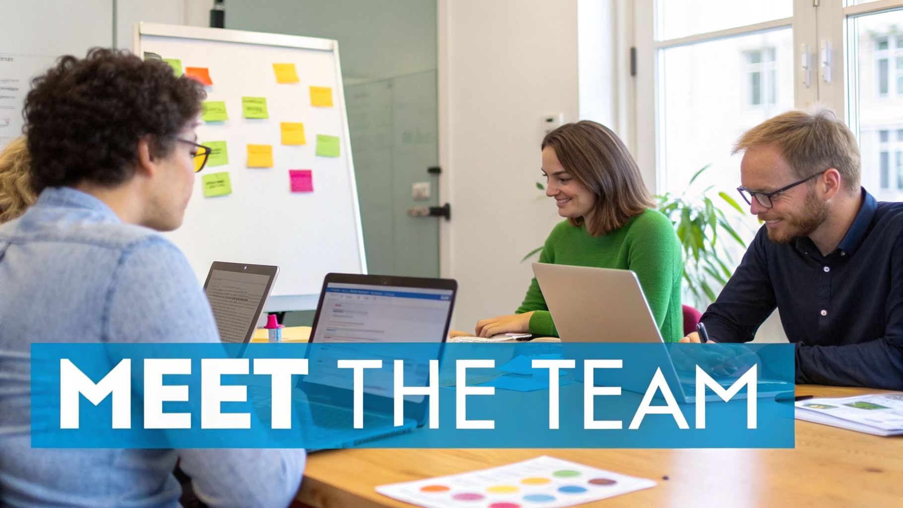 Three diverse team members working collaboratively on laptops in a bright, modern office setting.