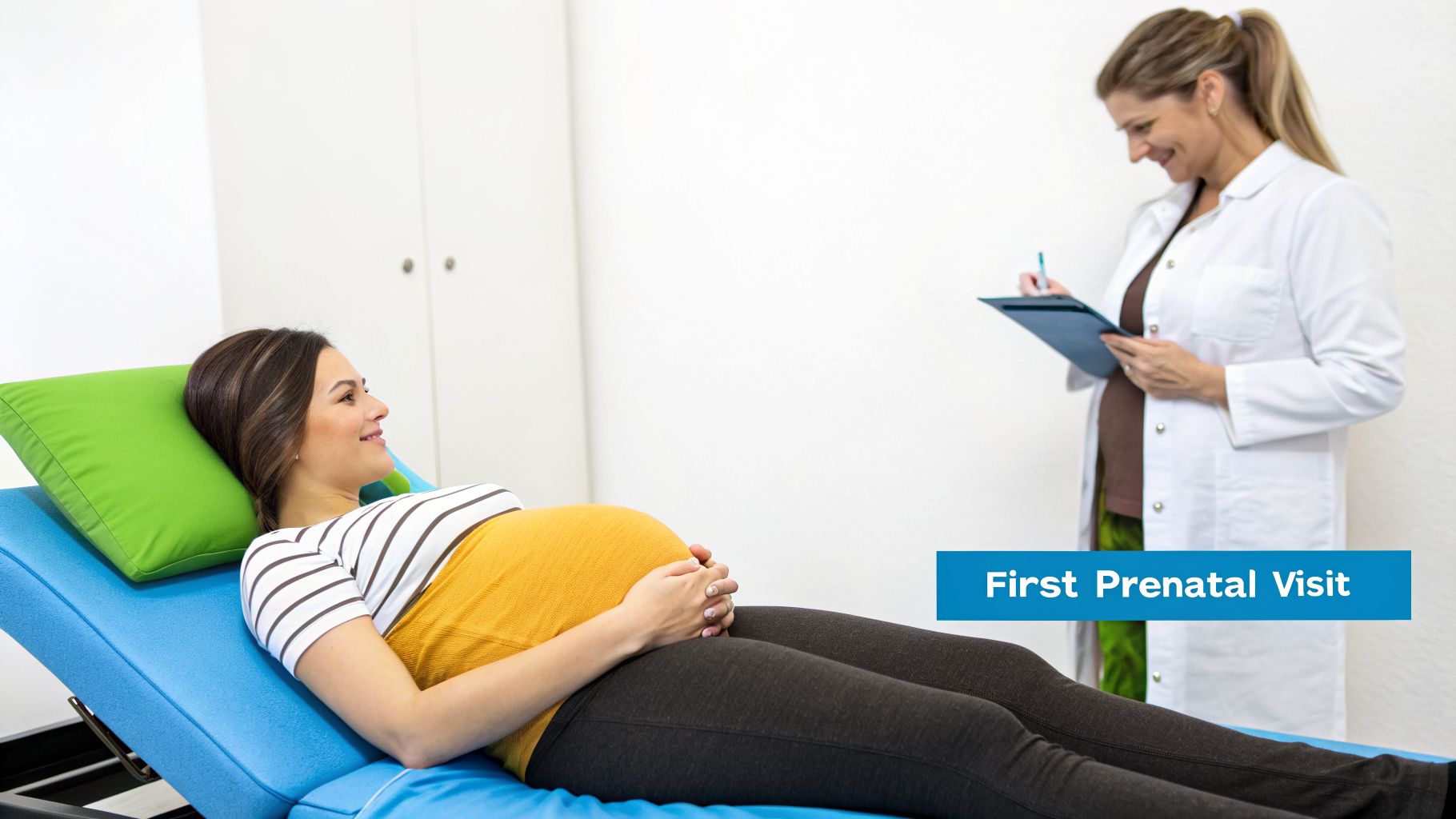 A smiling pregnant woman on an examination bed with a doctor writing notes during a prenatal visit.