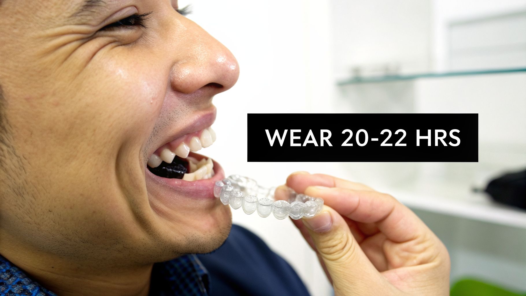 A person preparing to wear a clear dental aligner, with text indicating 'WEAR 20-22 HRS'.