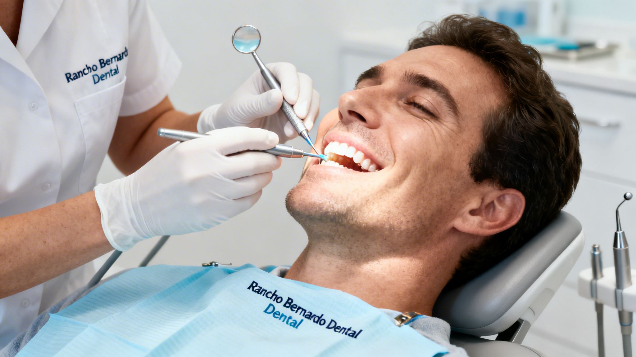 A happy man receives a dental cleaning from a gloved professional in a modern dental office.