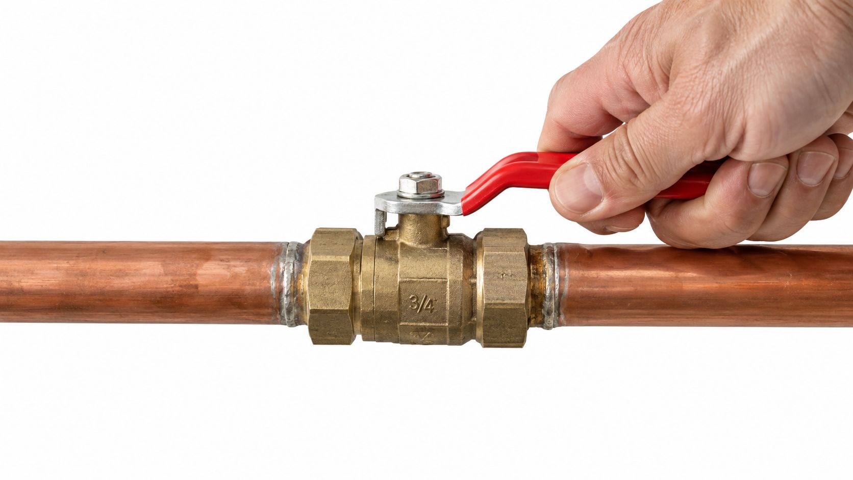 A hand closing a brass ball valve on a copper pipe system to shut off water supply.