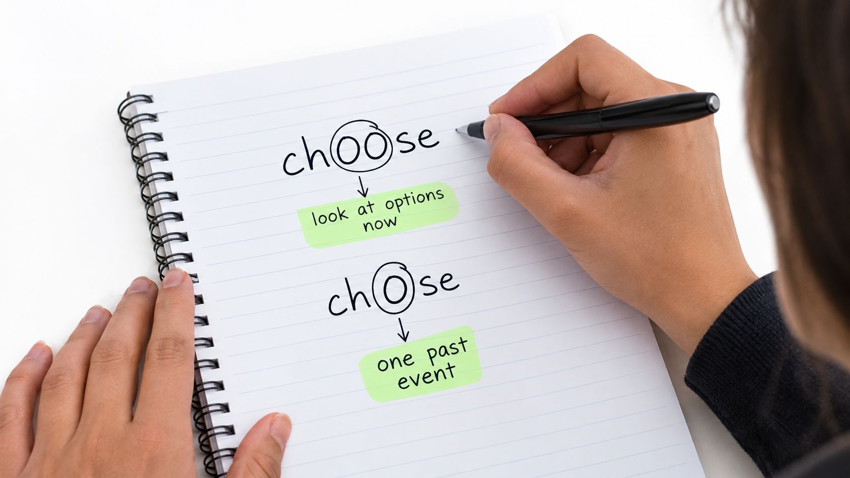 A person writing a memory trick in a notebook, circling the letters in 'choose' and 'chose' to remember their tenses.