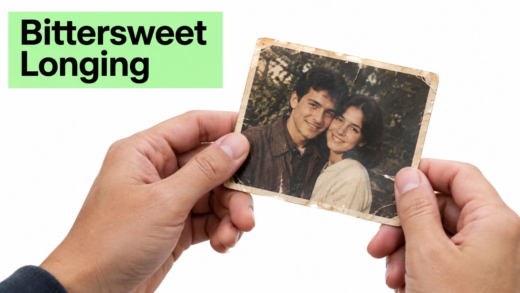 A pair of hands holding an old, worn photograph of a smiling young couple in love.