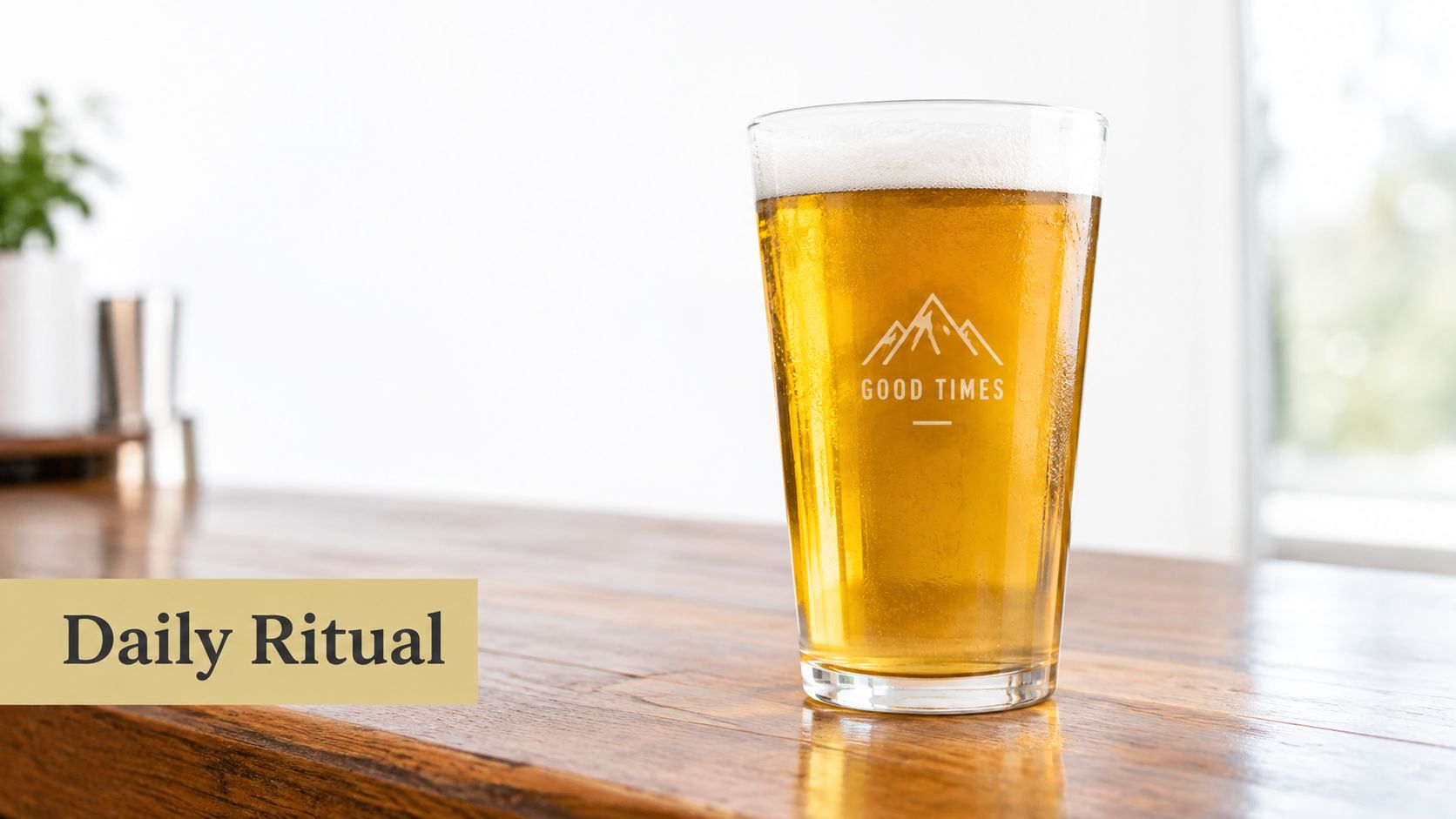 A glass of beer with a mountain logo and the text Good Times on a wooden bar.