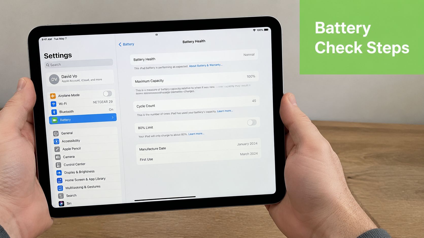 A person holding an iPad displaying battery health and capacity settings screen in the iOS settings menu.