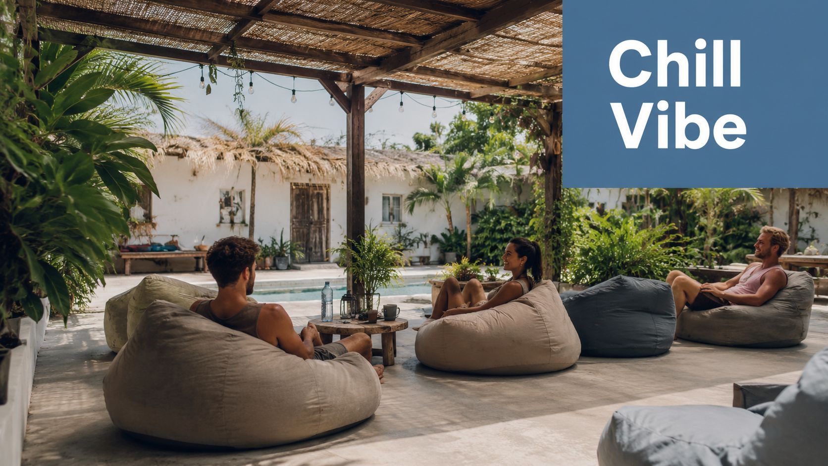 A group of young people relaxing on comfortable bean bag chairs at a sunny tropical hostel patio.