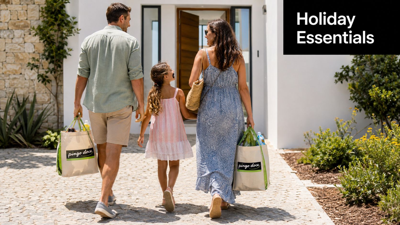 A happy family walking towards their home while carrying Pingo Doce reusable grocery shopping bags.
