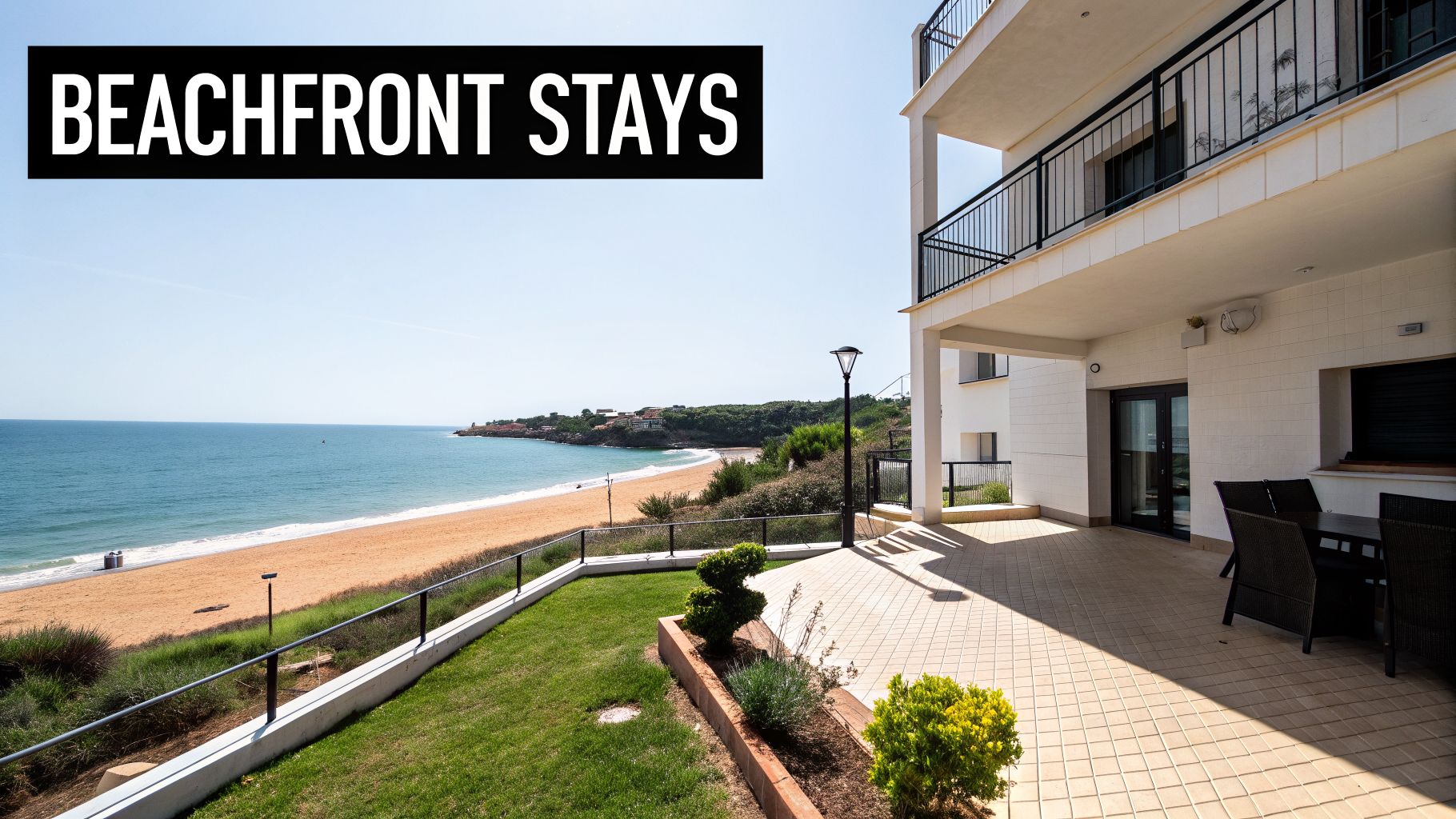 A modern beachfront apartment building with a patio and lawn overlooking a beautiful sandy beach and ocean.