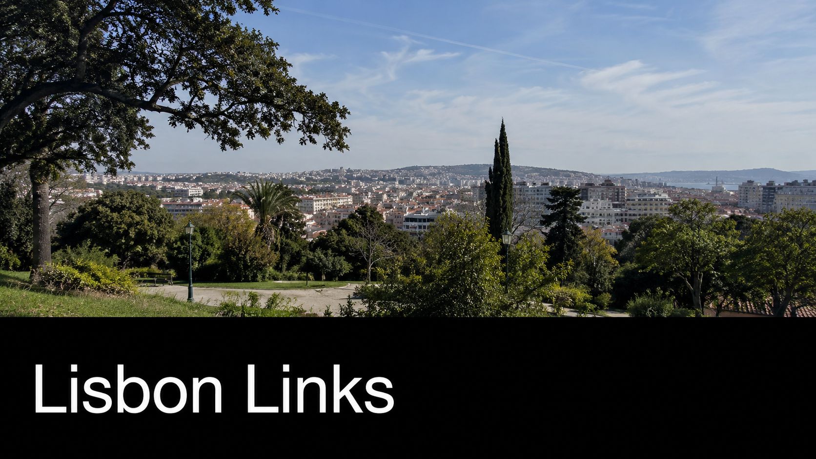 A wide scenic view of the Lisbon cityscape viewed from the greenery of Parque Keil do Amaral.