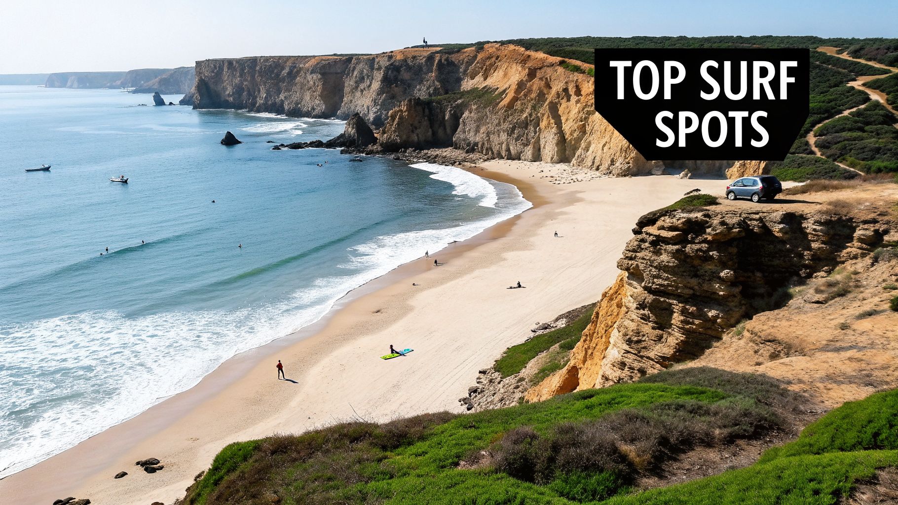 Panoramic view of a sandy beach with surfers and waves, backed by majestic cliffs and lush greenery.