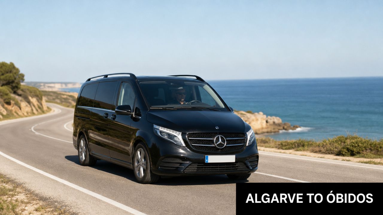 A black Mercedes-Benz minivan driving along a scenic coastal road towards the town of Óbidos, Portugal.