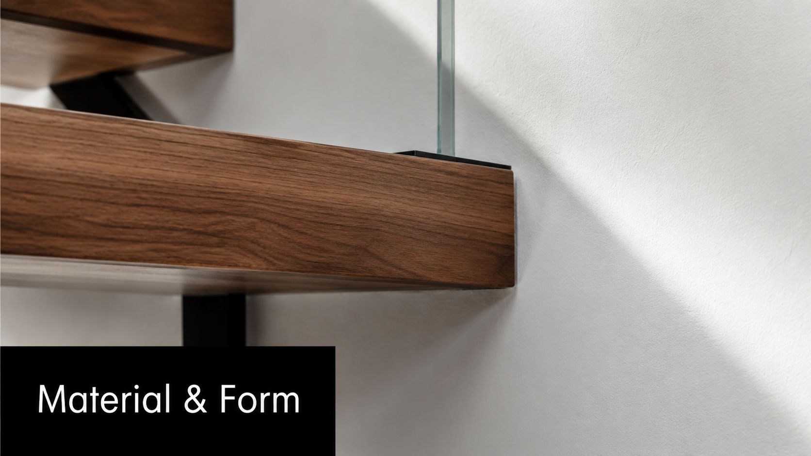 A close-up view of a modern bespoke staircase featuring walnut wood treads and glass railings.