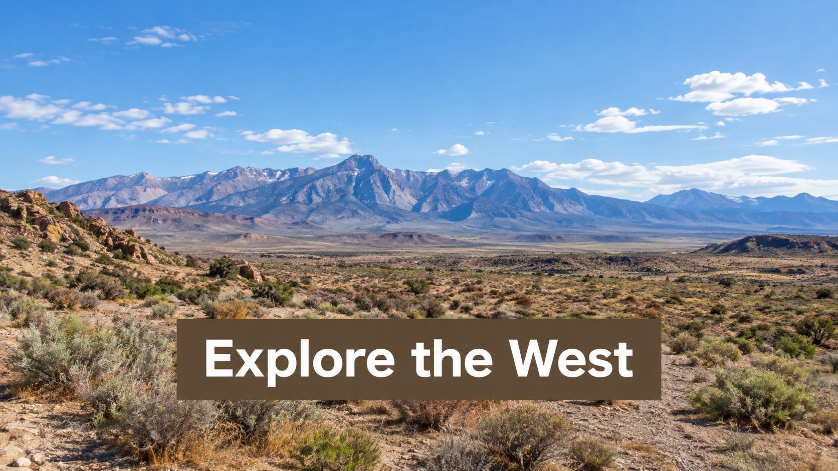 A scenic view of a vast desert landscape with majestic mountains under a bright blue sky.