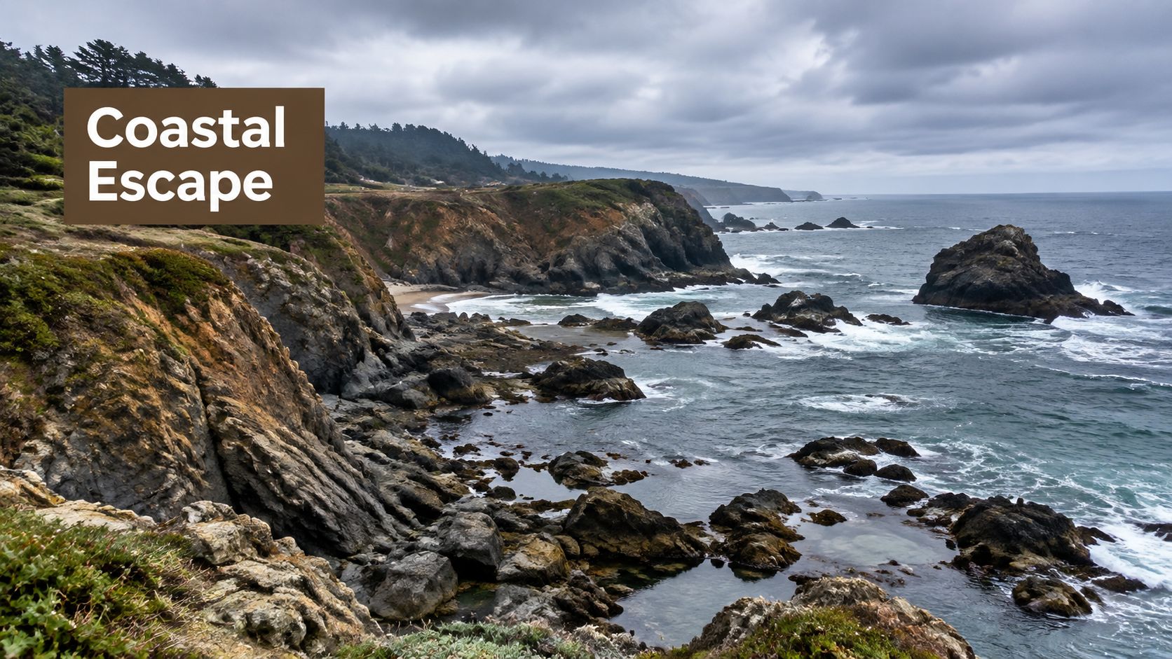 A scenic view of a rocky California coastline with crashing waves under a moody, cloudy sky.