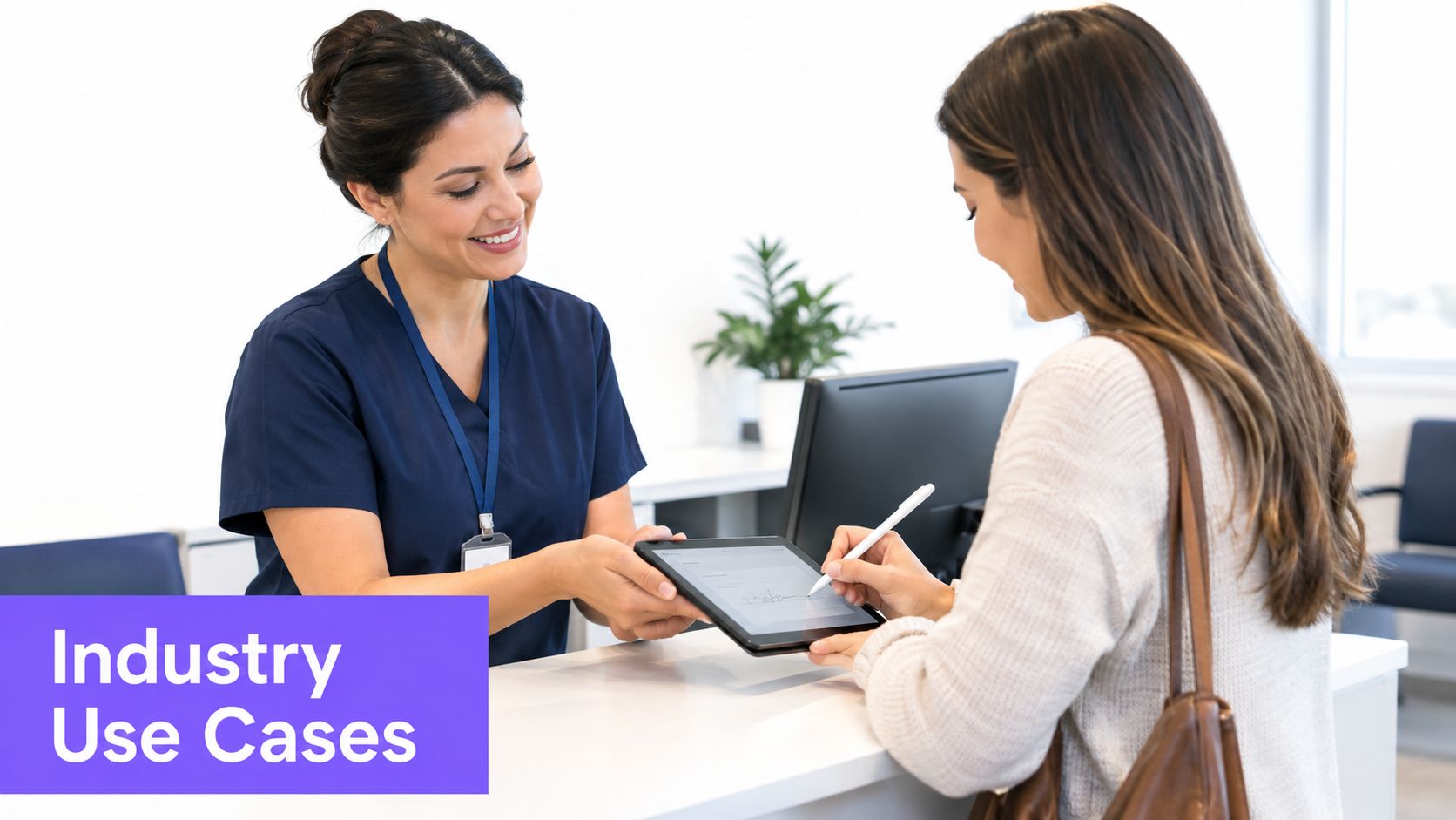 A friendly receptionist in blue scrubs hands a tablet to a patient to sign digital documents.