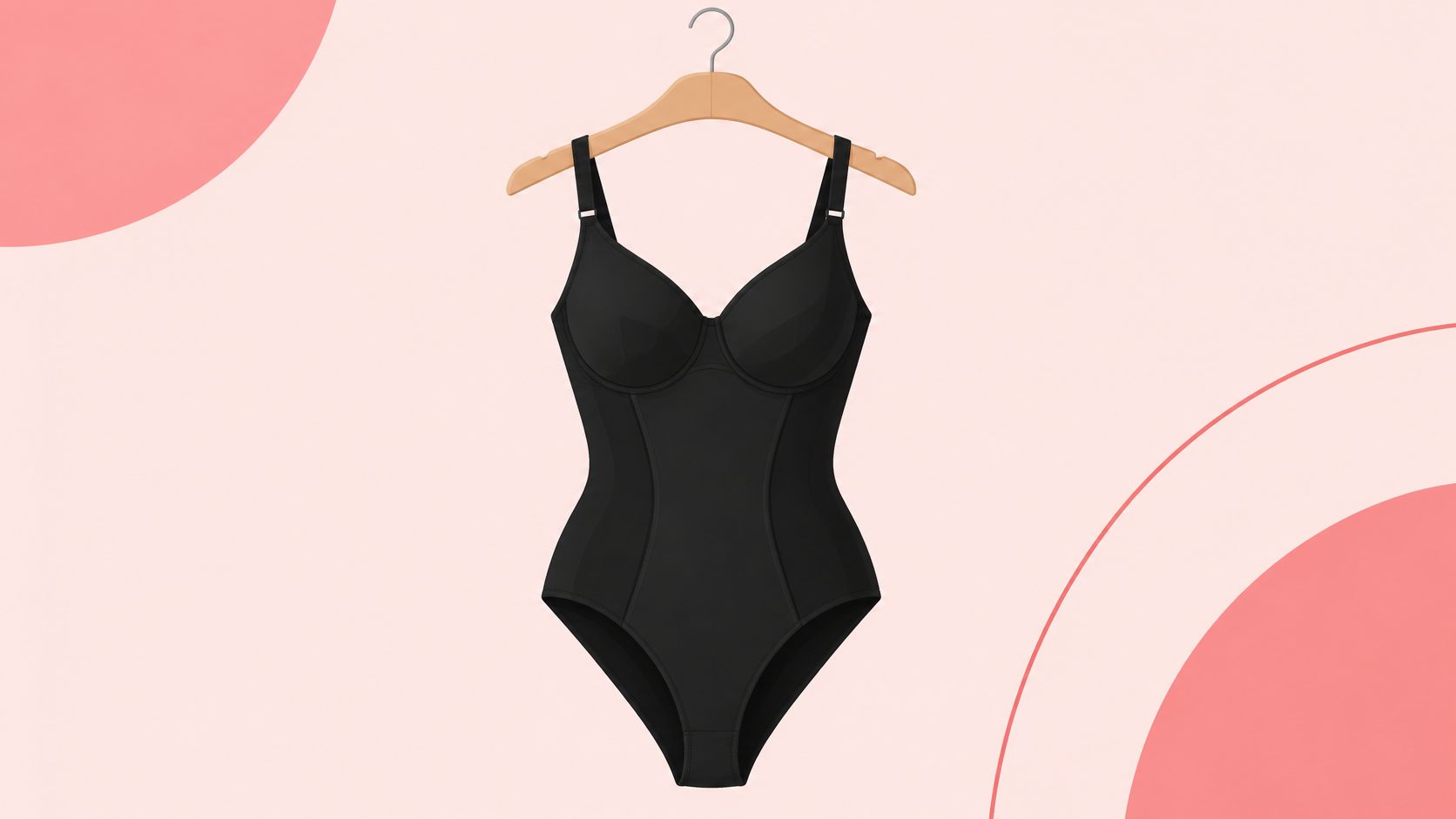 A black full-body slimming shapewear bodysuit hanging on a wooden hanger against a soft pink background.