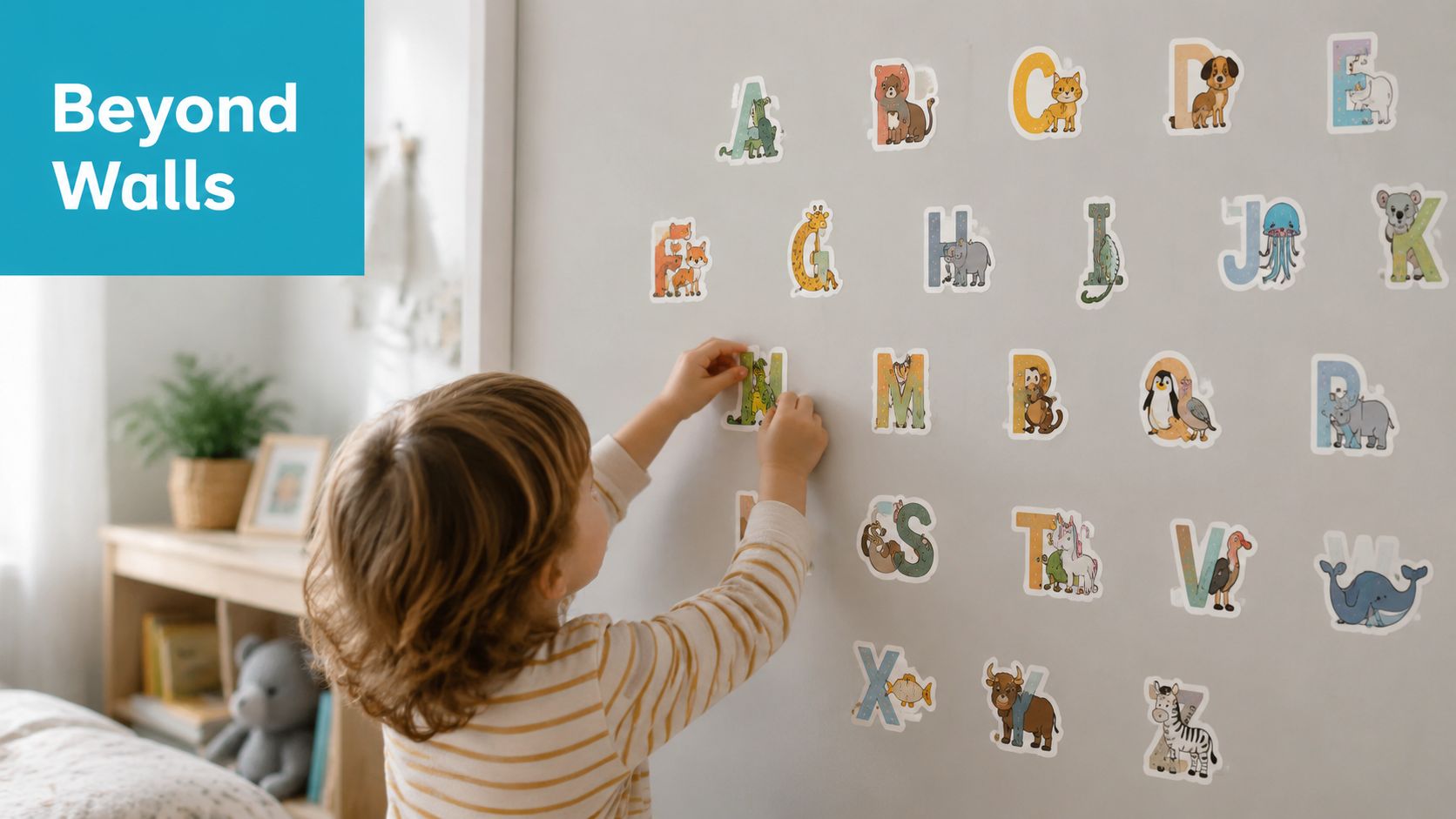 A young child decorating a light-colored bedroom wall with colorful alphabet stickers of various animals.