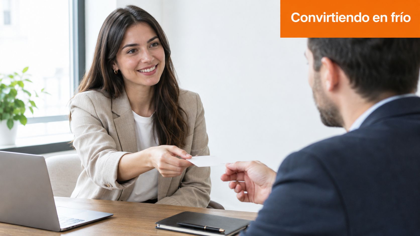 Una profesional sonriente entrega su tarjeta de visita a un cliente potencial en una oficina moderna.