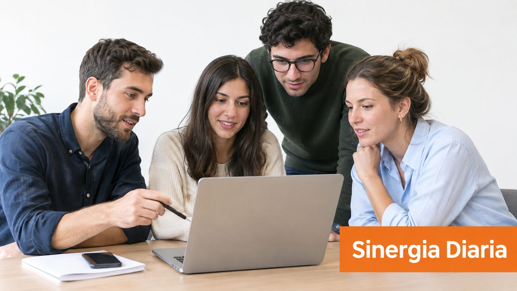 Un grupo de cuatro profesionales colaborando en una computadora portátil durante una reunión de equipo en la oficina.