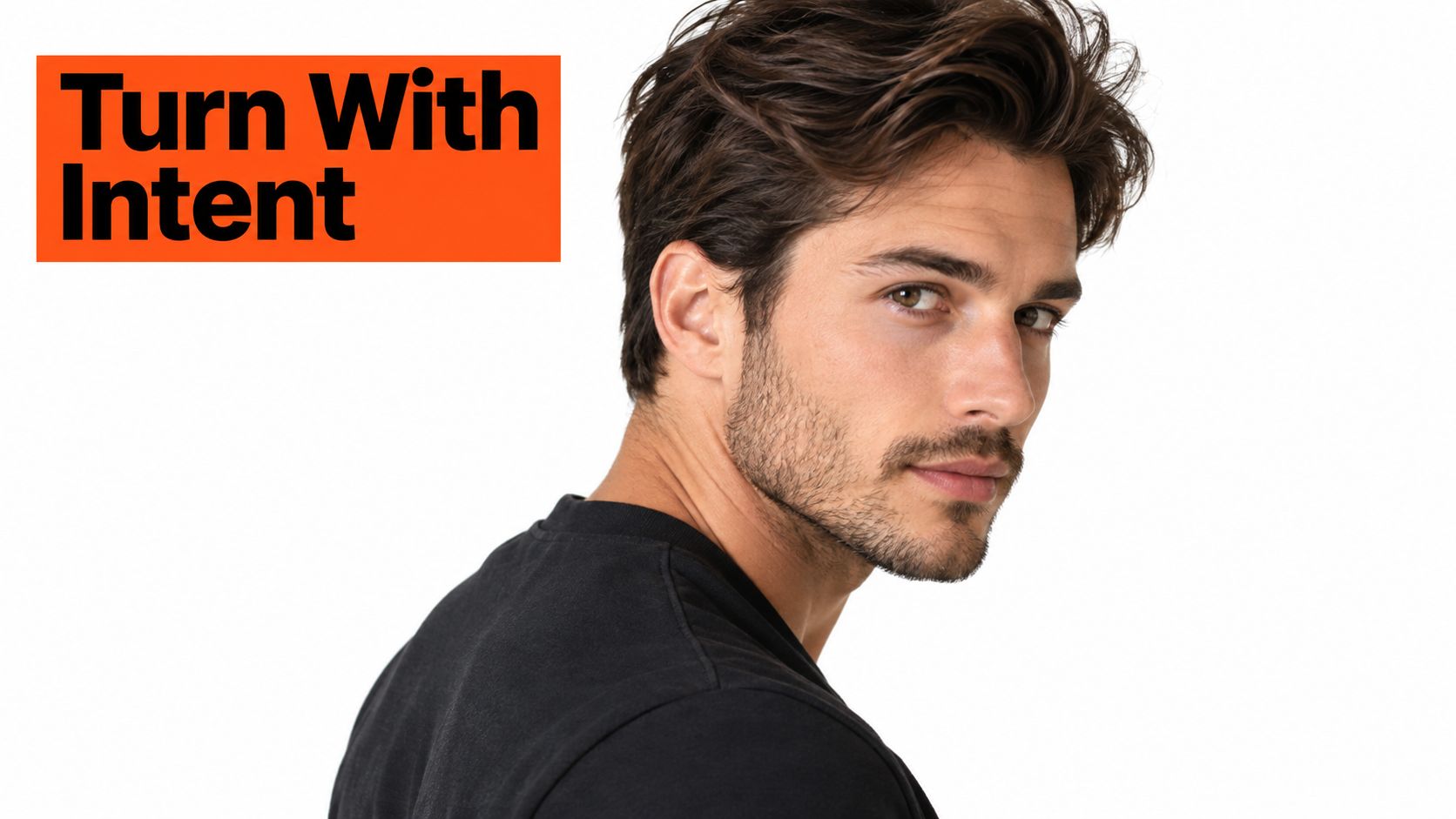 A close-up portrait of a handsome young man with brown hair, beard, and black shirt.