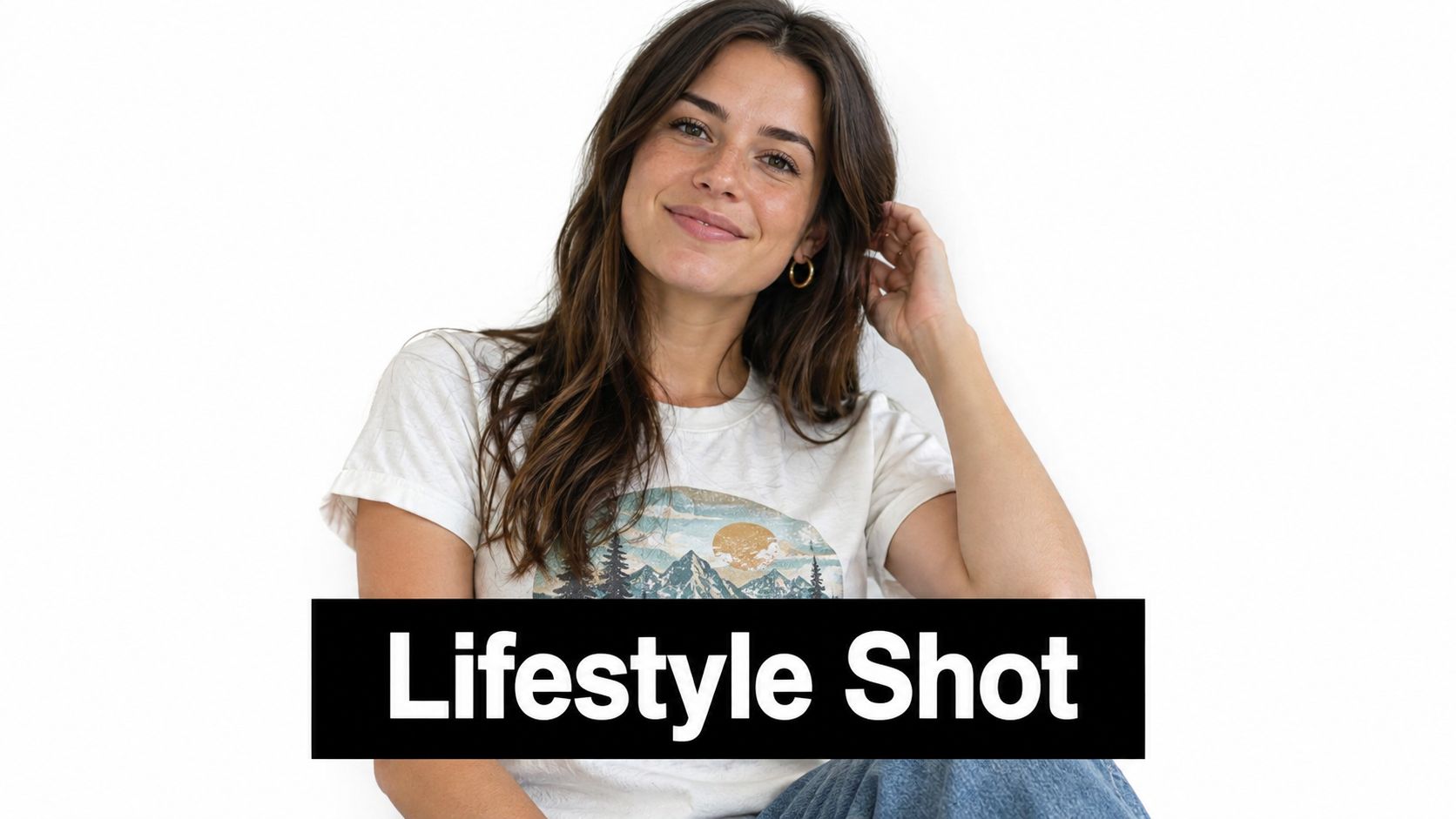A young woman with brown hair smiling comfortably while wearing a graphic t-shirt against a white background.