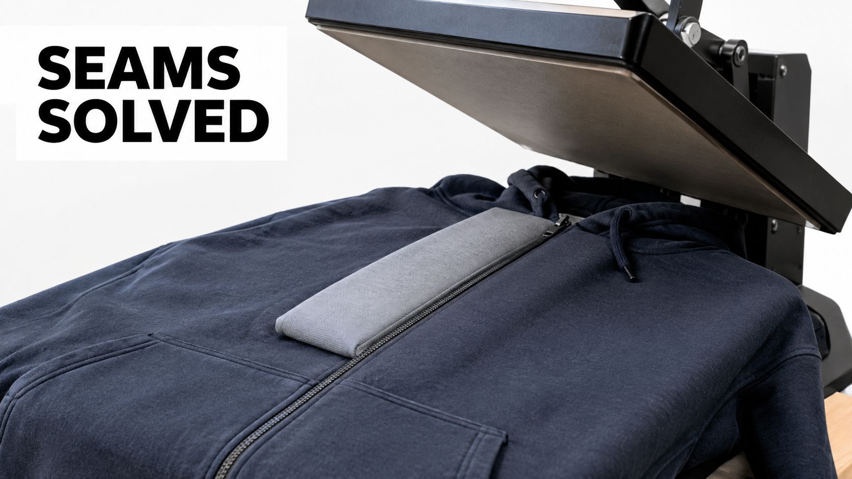 A gray heat press pillow placed on a navy blue zipper hoodie for professional heat transfer printing.