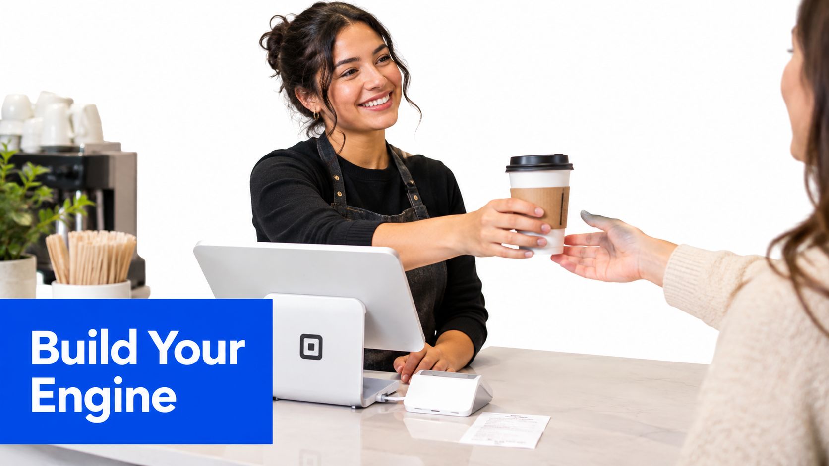A friendly barista handing a hot coffee to a customer across a cafe service counter.
