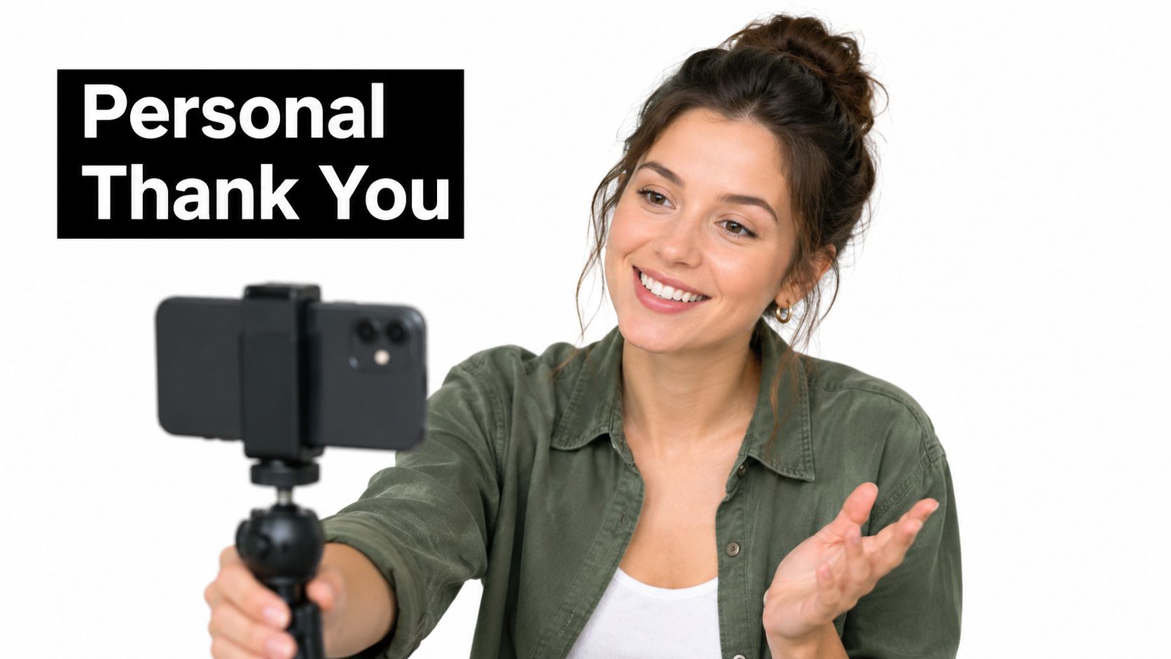 A smiling woman recording a personal thank you video message on her smartphone using a small tripod.