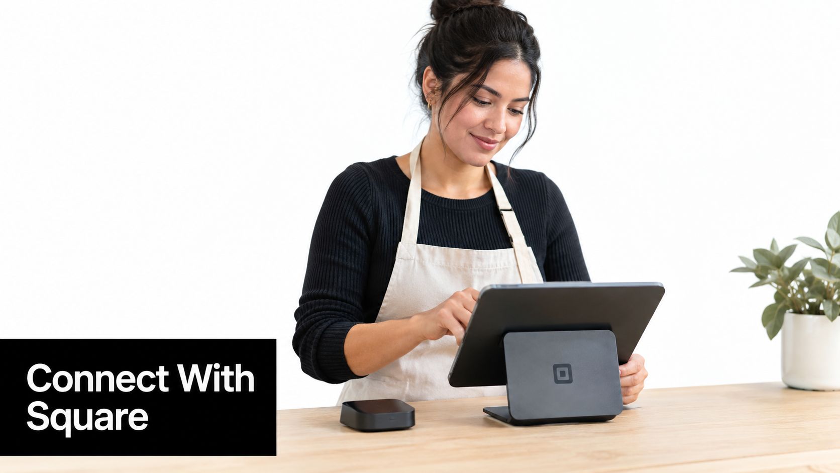 A woman wearing an apron uses a Square point of sale tablet system to manage customer transactions.