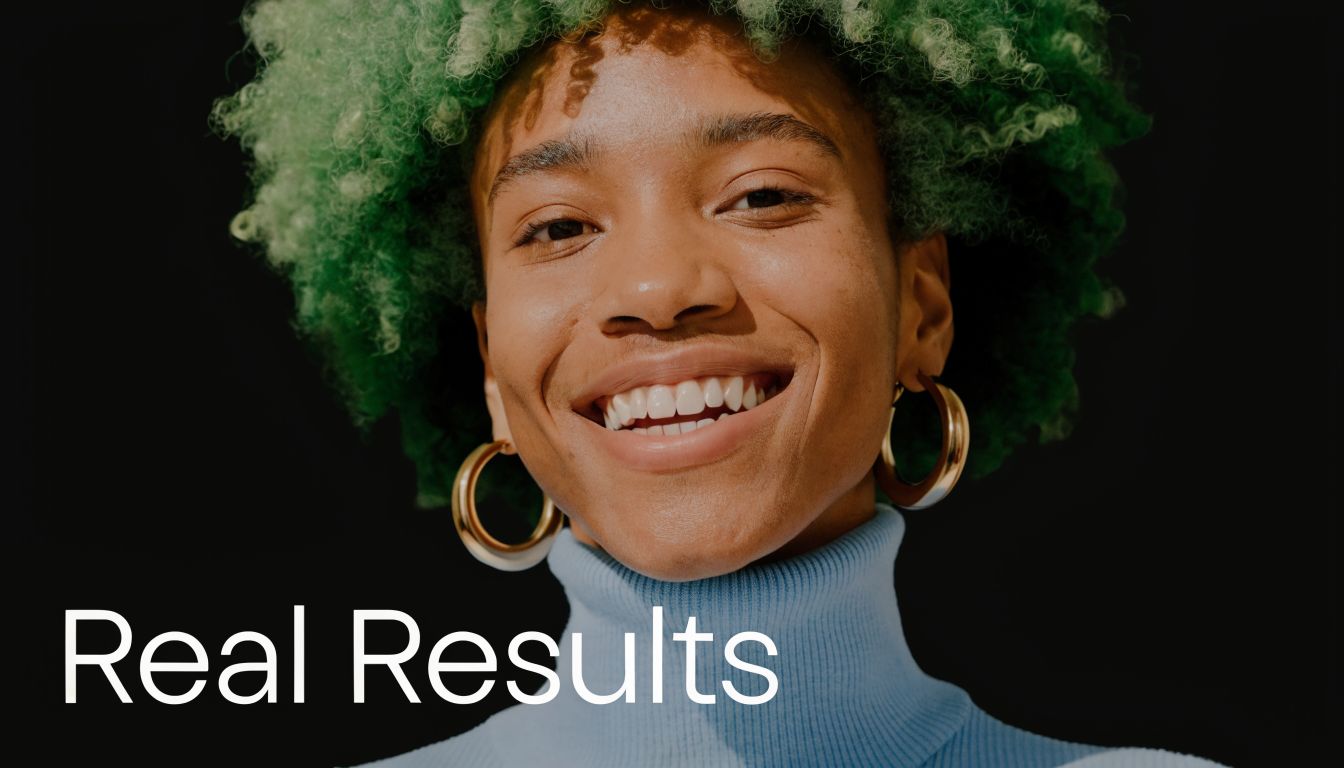 A close-up portrait of a smiling person with curly green hair wearing gold hoop earrings.