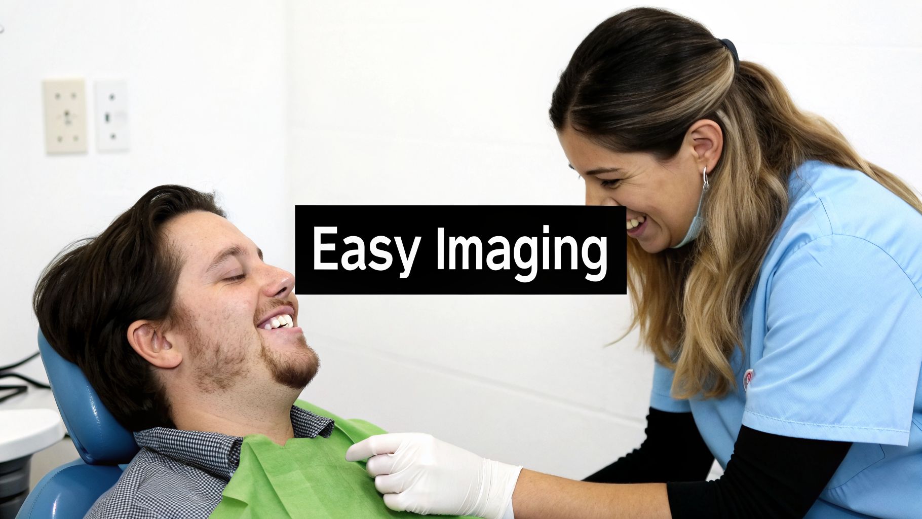 A happy male patient in a dental chair is attended by a smiling female dental professional.