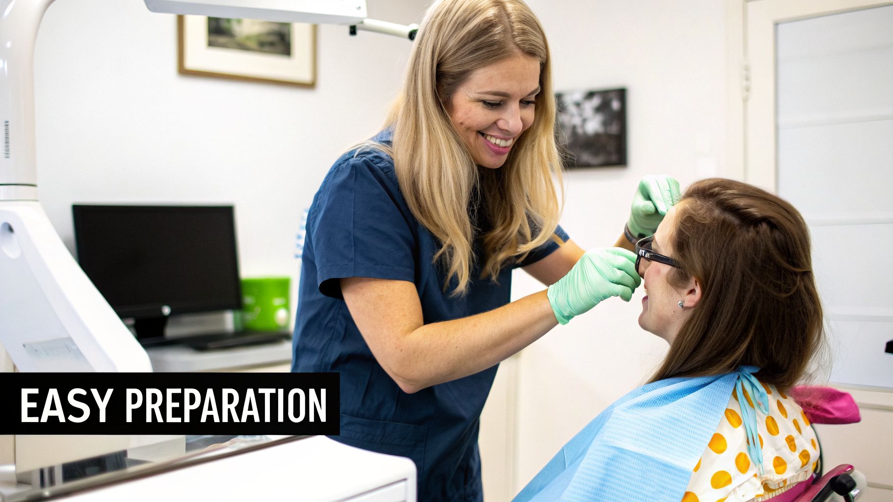 A smiling dental professional in green gloves prepares a female patient for a procedure.