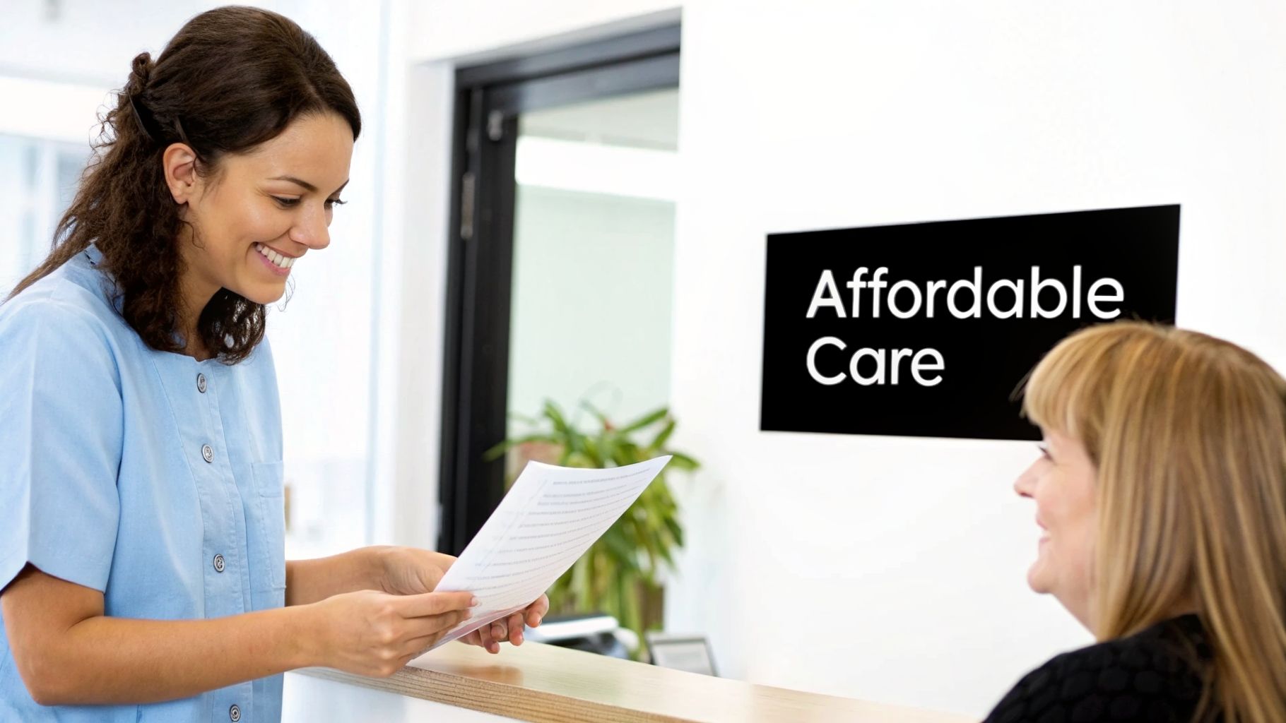 A smiling female healthcare worker in a light blue uniform holds papers, assisting a patient at a reception desk with an 'Affordable Care' sign.