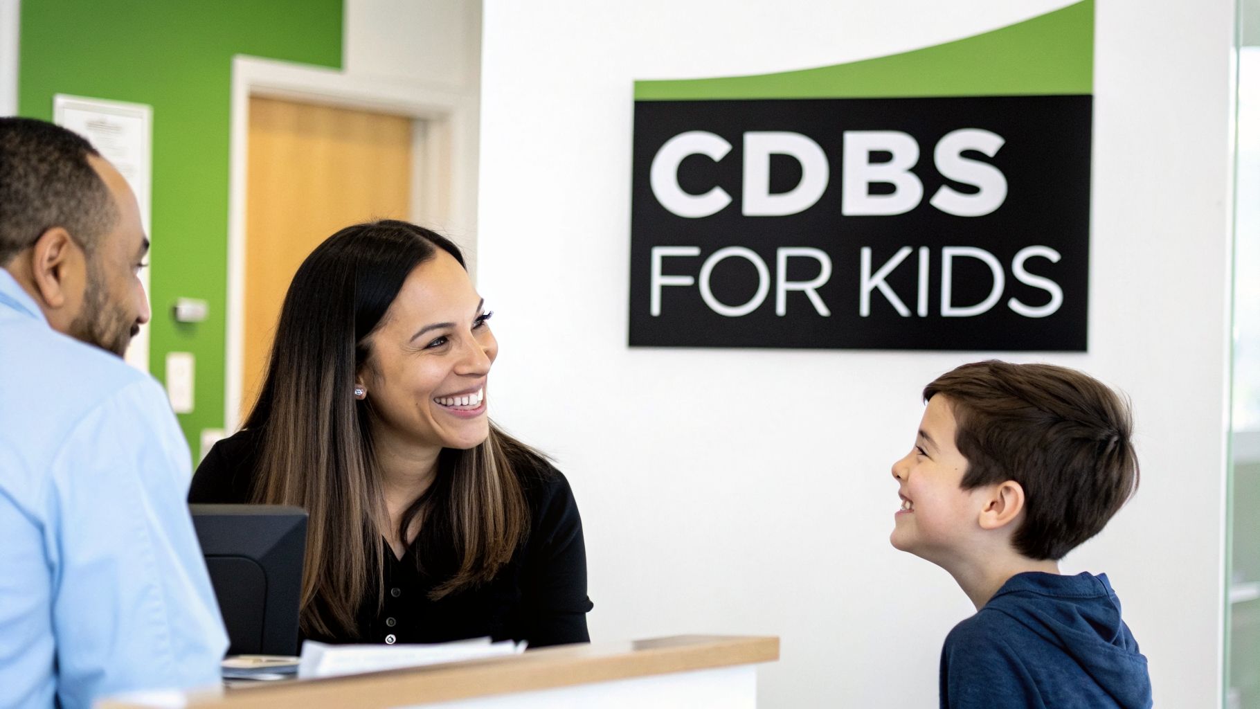 A smiling woman interacting with a happy boy at a clinic reception, with a man nearby.