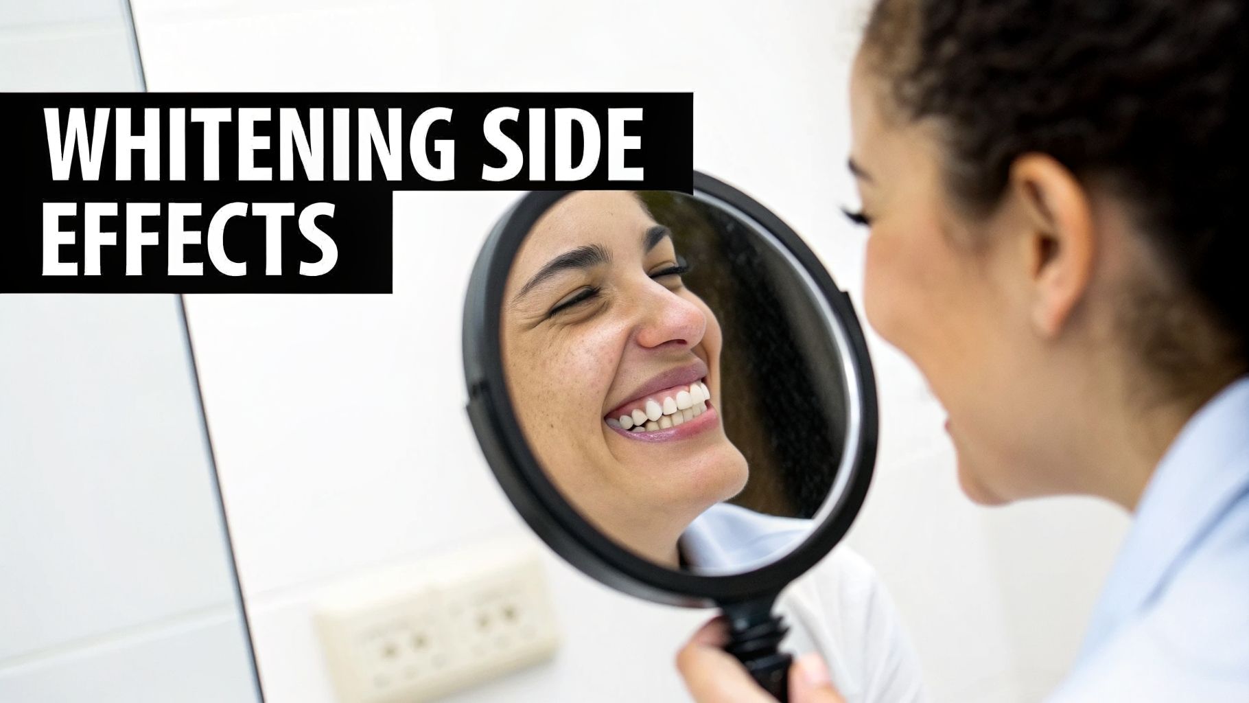 A happy woman smiles into a handheld mirror, showing her bright, white teeth.