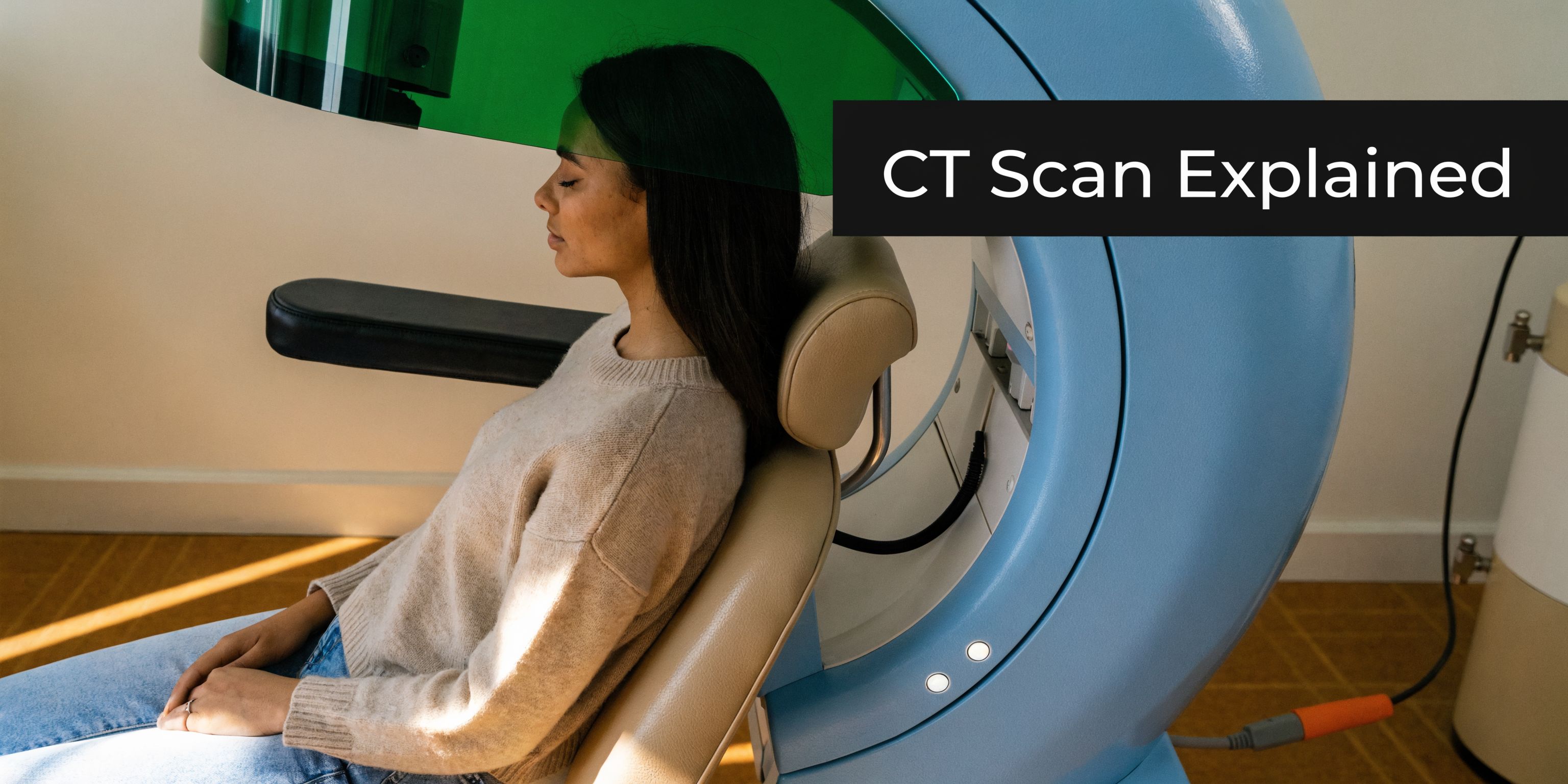 A young woman sits in a chair receiving a dental computed tomography scan in a clinic.