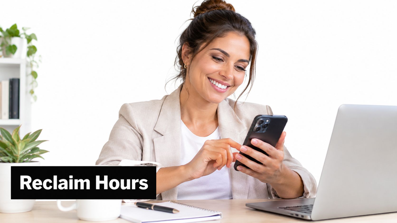 A professional woman smiling while using her smartphone at a desk with a laptop and planner.
