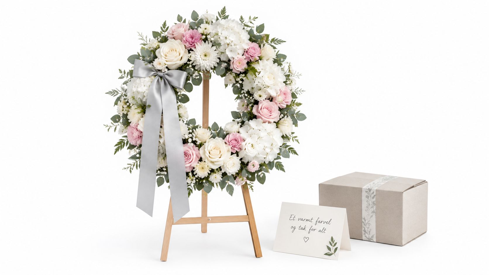 En smuk blomsterkrans på et træstativ med bånd, et kort og en gaveæske til en begravelse.