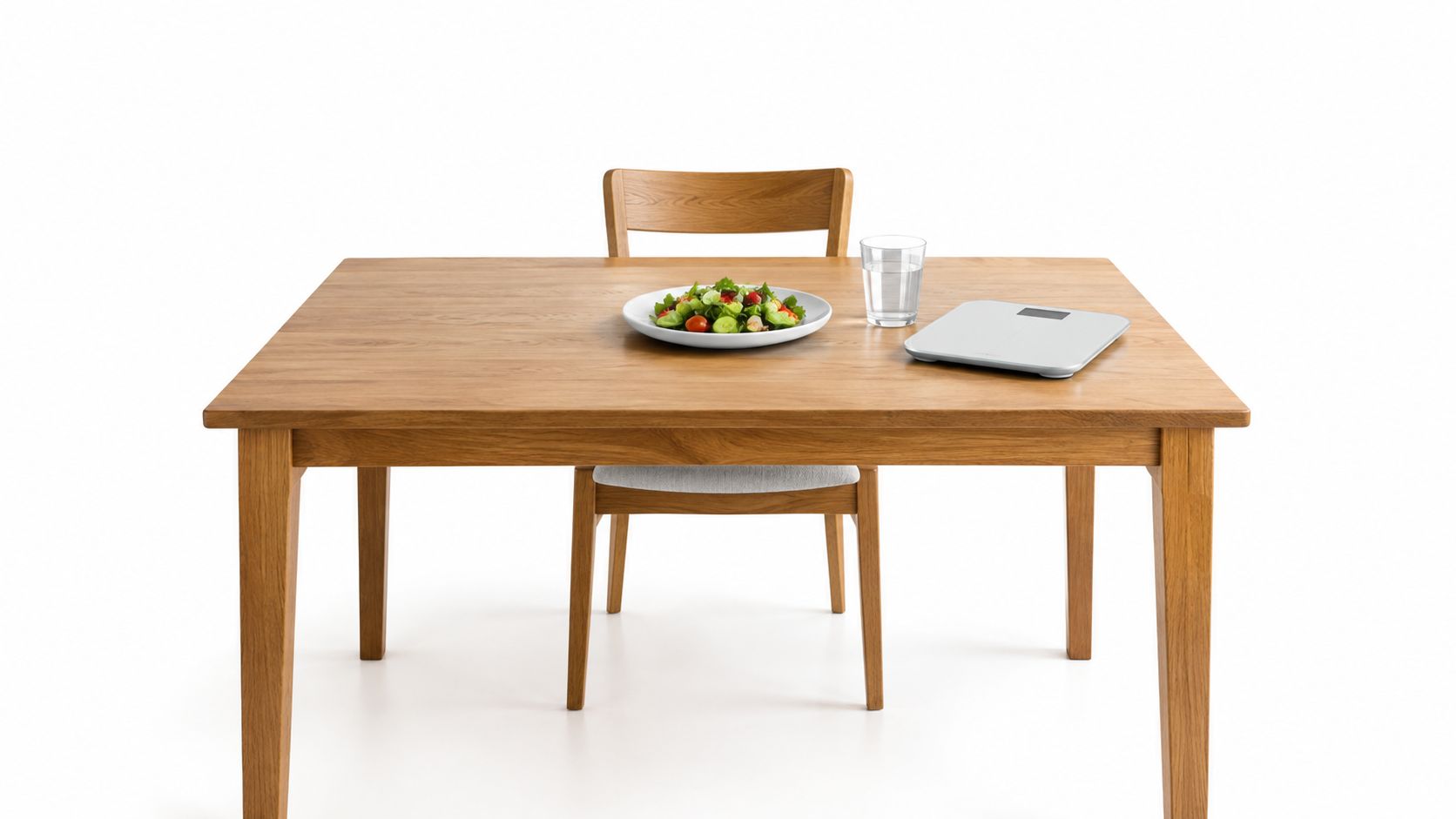 A healthy salad on a plate with a glass of water and a digital scale on a table.