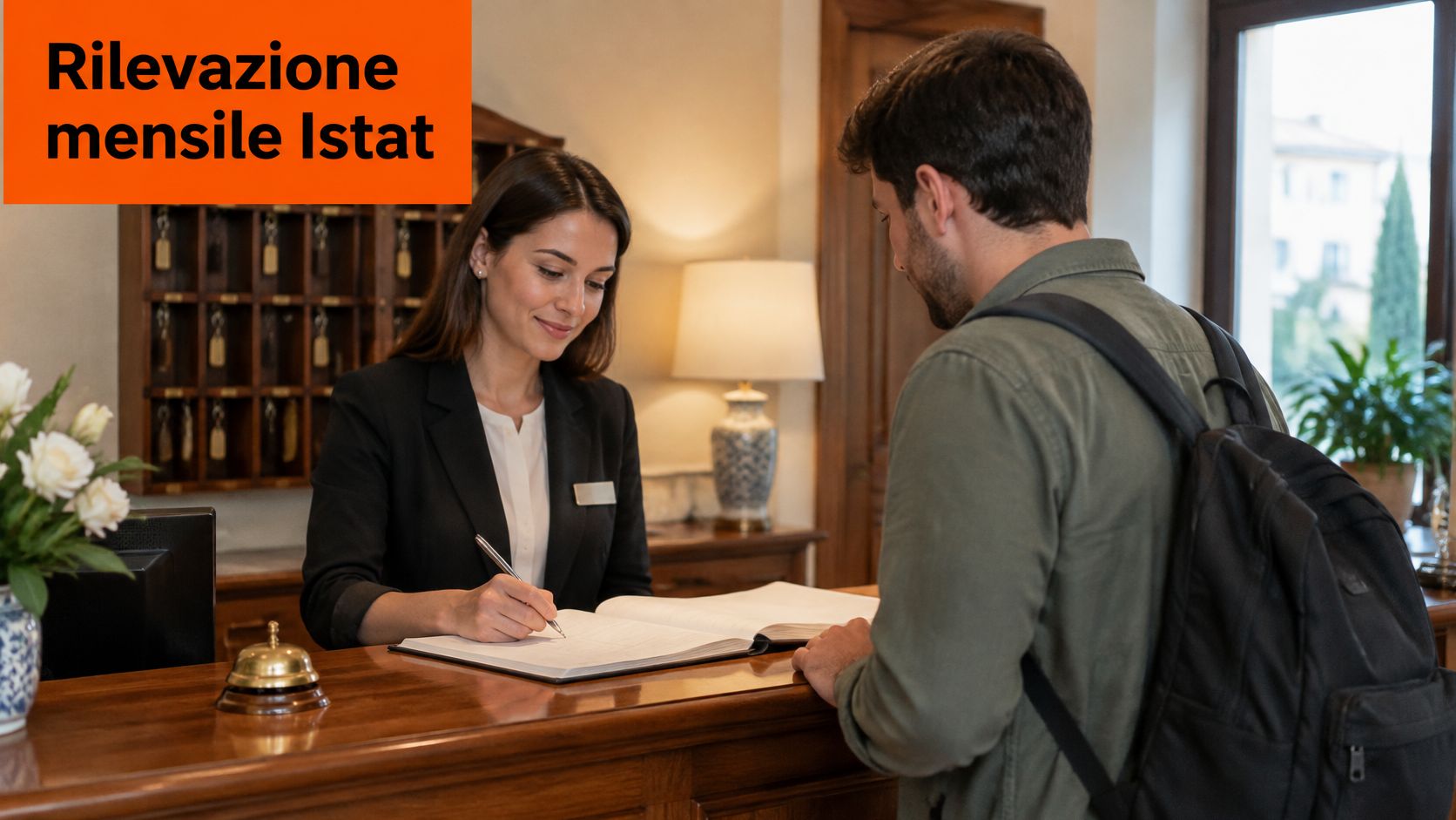 Receptionista di hotel accoglie un ospite al banco durante la rilevazione mensile Istat nelle strutture ricettive.
