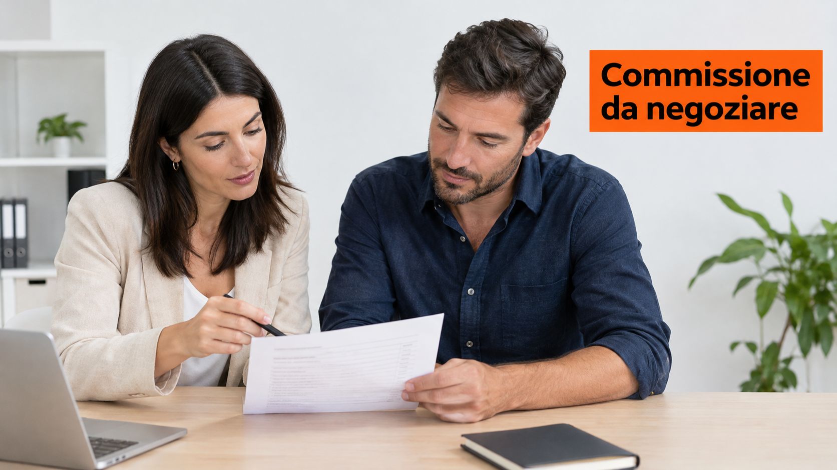 Una consulente e un cliente analizzano insieme un documento cartaceo seduti a una scrivania in ufficio.