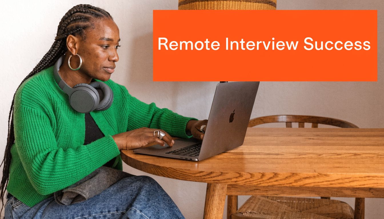 A Black woman with braided hair wearing a green sweater using a laptop at a wooden table.
