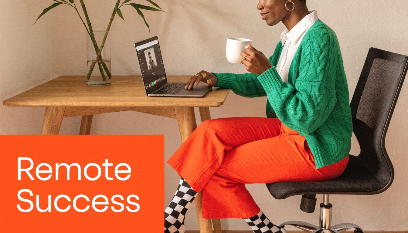 A woman working remotely at a desk with a laptop while drinking coffee in a bright office.