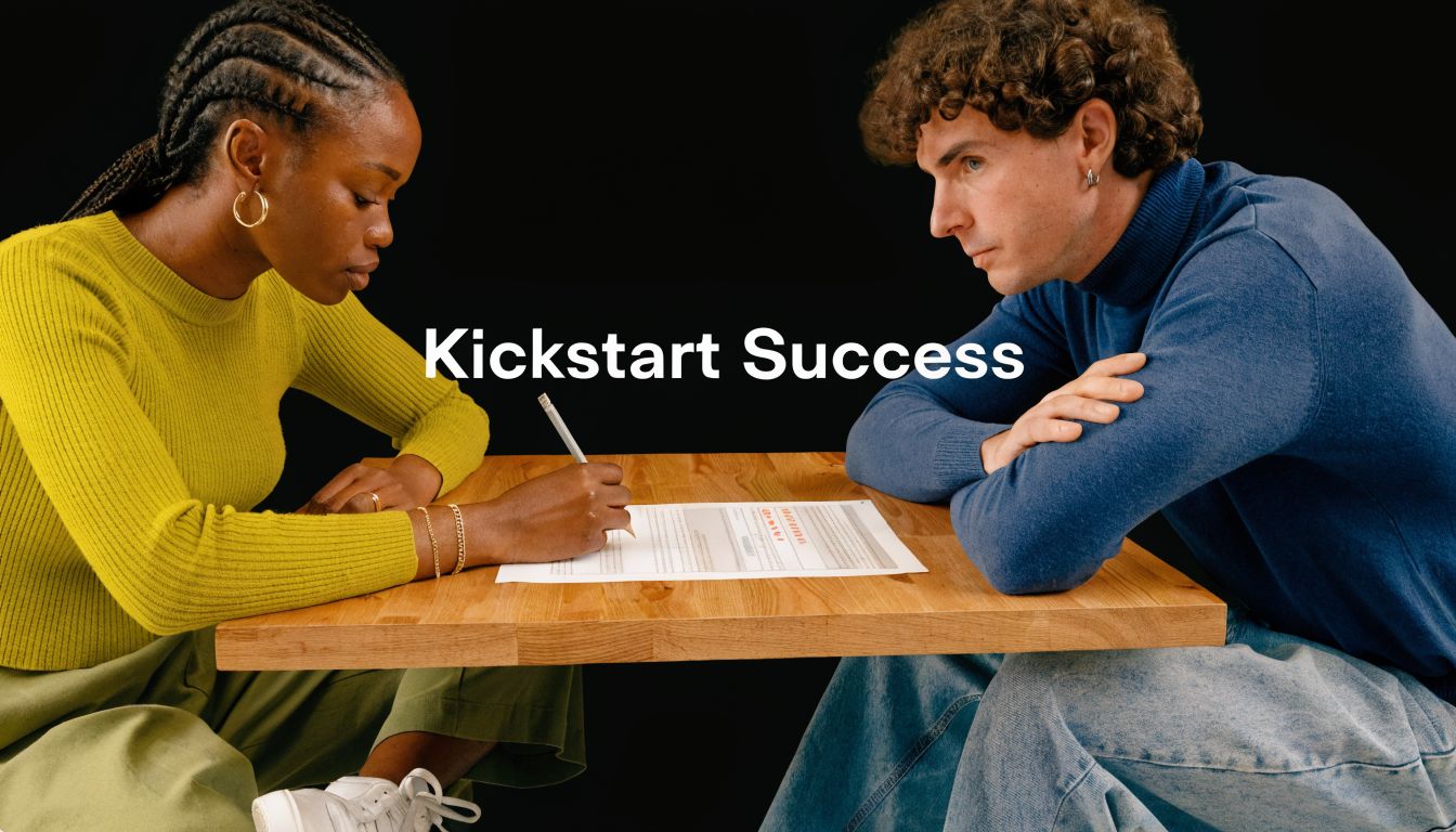 A woman and a man sitting at a table working together on a document on a black background.