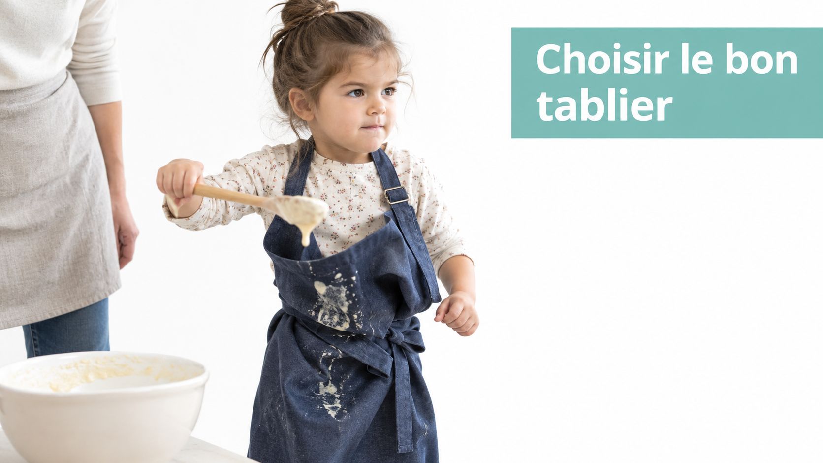 Une jeune enfant portant un tablier bleu en jean tout en cuisinant avec une cuillère en bois.